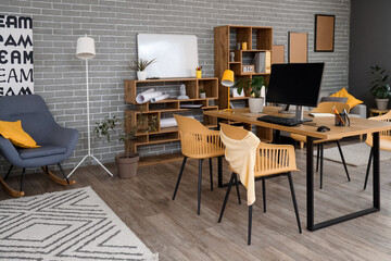 Interior of stylish office with workplace, shelf units and plants