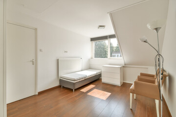 A bright and airy modern bedroom featuring a minimalist design with wooden flooring, simple furniture, and ample natural light.