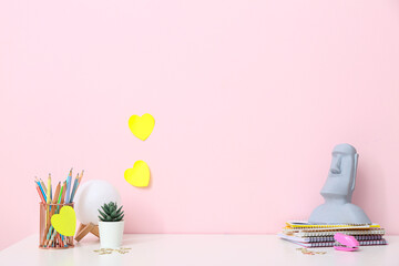 Stylish workplace with statuette and stationery in office