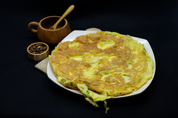 Homemade Indonesian-Style Omelet on White Plate with Rustic Kitchen Props
