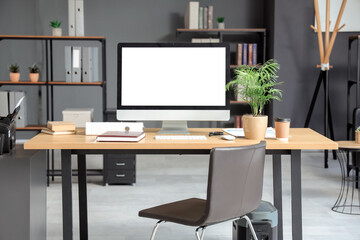 Interior of stylish office with workplace, modern computer and chair