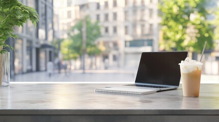 Laptop and iced coffee on sidewalk cafe table with blur