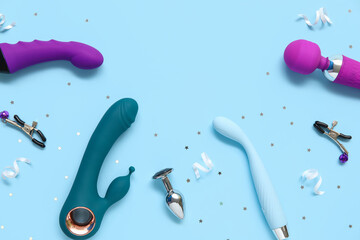 Different vibrators with nipple clamps and anal plug on blue background