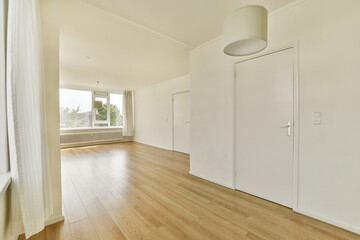 A spacious interior featuring elegant flooring and natural light streaming through large windows, creating a warm and inviting atmosphere.