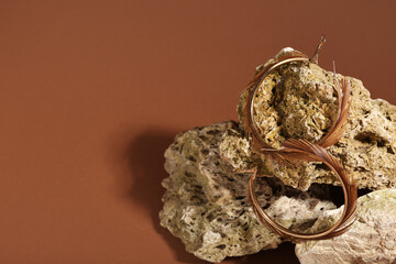 Stone with beautiful earrings on brown background