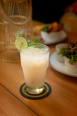 Cold lime juice with probiotic drink mix. Served with dried lime slices and mint leaves. Drink on wooden brown table. Perfect for advertising and commercial purpose