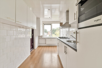 A sleek and minimalist kitchen featuring clean lines, ample natural light, and contemporary furnishings. Ideal for modern living spaces and interior design inspiration.
