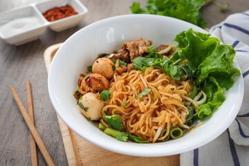 Steamed  thin noodles without soup in white bowl on wooden background 