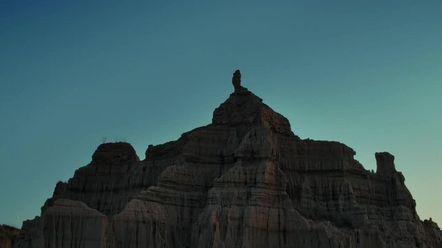 Sandstone cliff standing under clear sky at sunrise in Chakwal Canyons of Pakistan