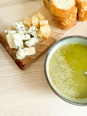 Delicious bread and cheese platter with olive oil and sesame seeds at a rustic table