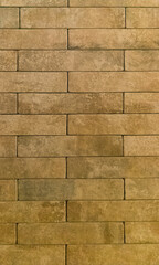 The brick wall is yellow. Brick yellow background. The texture of the yellow brick. Vertical image.