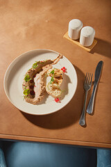 Culinary art displayed on a plate featuring a unique dish with garnishes in a modern dining setting