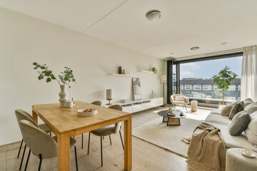 A contemporary living room showcasing minimalist decor with natural light, wooden furniture, and elegant furnishings creating a welcoming ambiance.