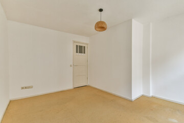 A clean, minimalist interior featuring neutral tones, a simple light fixture, and a door, providing a spacious and uncluttered ambiance.