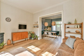 A stylish modern living room featuring wooden flooring, minimalist furniture, and tasteful decor elements that enhance comfort and aesthetic appeal.