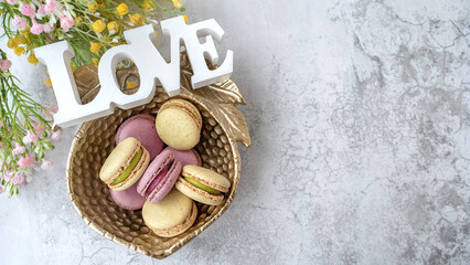 Colorful Macarons Arranged Beautifully in an Ornate Bowl at a Spring Outdoor Gathering. Top view. Copy space