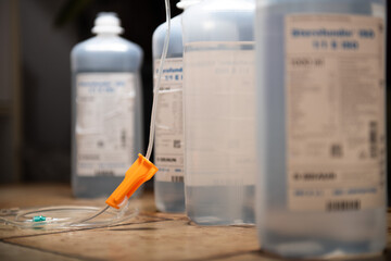 medicine bottle and syringe. infusion bags standing in a row with dark background. symbolic illness mood chancer. hospital equipment for healthcare. detail