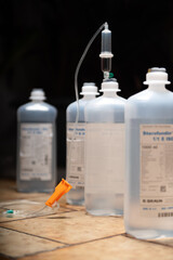 medicine bottle and syringe. infusion bags standing in a row with dark background. symbolic illness mood chancer. hospital equipment for healthcare.