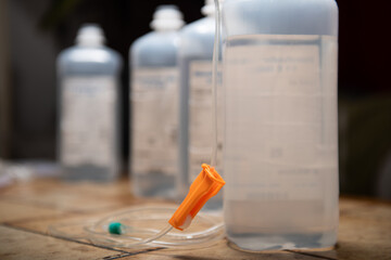 medicine bottle and syringe. infusion bags standing in a row with dark background. symbolic illness mood chancer. hospital equipment for healthcare. detail