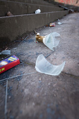 new years eve trash and broken sparkling wine glass on sidewalk