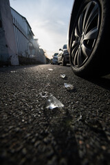 broken glass and tire on the road. frog perspective backlight. symbolic accident. car crash