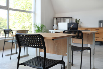 Desks and chairs in modern empty classroom