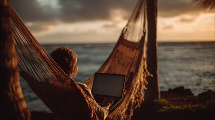 A person relaxes in a hammock by the serene ocean, using a laptop as the sun sets, blending nature with technology in a peaceful moment.