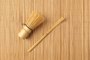 Bamboo whisk and scoop resting on a bamboo mat for matcha preparation
