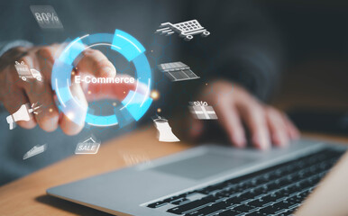 Human hand pressing E-Commerce button to access in online shopping website that access to global marketplace that has variety of products and services. Global online business, E-Commerce platform.