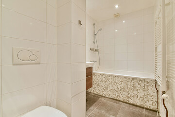 Sleek and contemporary bathroom featuring a blend of neutral tiles, a bathtub, and stylish fixtures for an elegant touch.