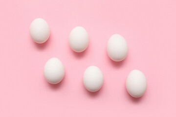 Chicken eggs on pink background