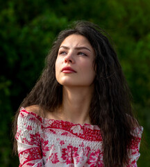 Naklejka premium Beautiful woman with dark hair portrait in nature in morning light