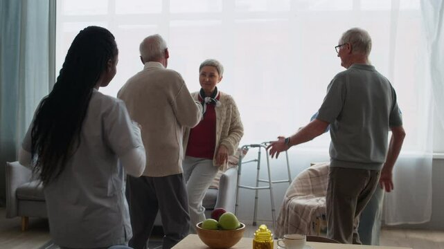 Group of elderly residents joyfully dancing with their young caregiver in bright, welcoming nursing home, promoting fun, movement, and emotional connection