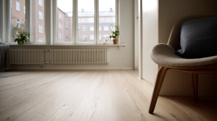 A bright, airy living room with large windows casts a warm glow over wooden flooring, embracing minimalism and modern comfort.
