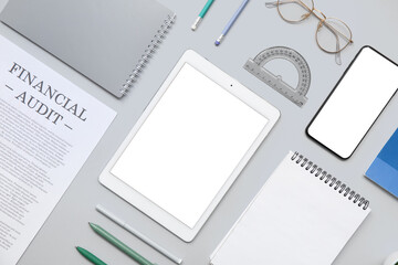 Composition with modern tablet computer, mobile phone, different stationery and financial documents on grey background