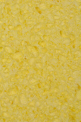 A close-up shot shows the porous and textured surface of a light yellow sponge