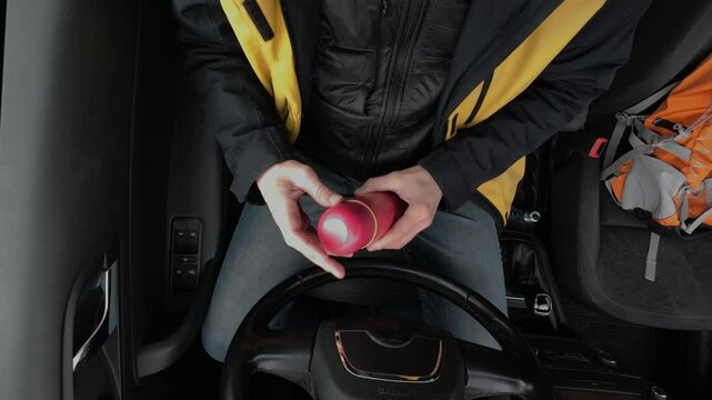 A person in a vehicle with unique drink containers embodies practicality for outdoor living, reflecting an adventurous and vibrant lifestyle full of excitement and exploration