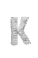 Handmade crocheted letter K in light grey yarn, isolated on white background