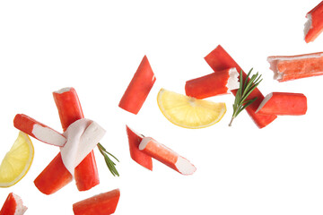 Tasty crab sticks with rosemary and slices of lemon flying on white background © Pixel-Shot