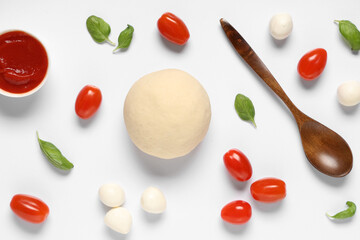 Raw dough, wooden spoon and ingredients for preparing pizza with mozzarella on white background