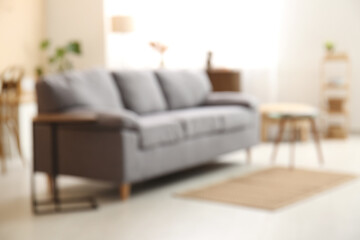 Interior of living room with cozy sofa and coffee table. Blurred view