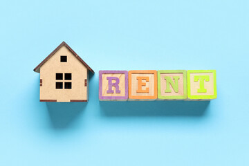 Toy house with word RENT on blue background