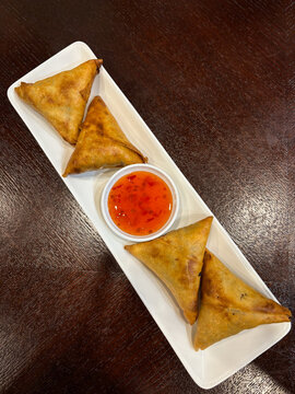A plate of sambossa with sweet chilli sauce.