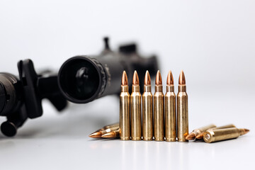 Close-up of firearm with bullets on light background.