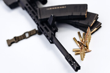 Close-up of firearm with bullets on light background.