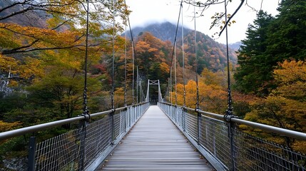 Obraz premium Scenic suspension bridge surrounded by vibrant autumn foliage showcasing nature's beauty in transition : Generative AI