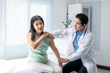 Fototapeta premium A woman is sitting on a bed with a doctor standing next to her