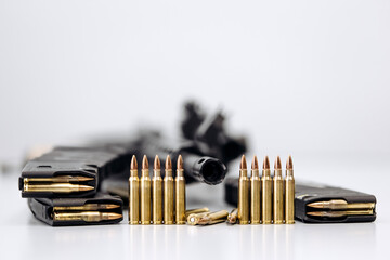 Close-up of assault rifle, ammunition and 7.62 caliber ammunition magazine on isolated light...