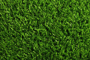 Artificial green grass texture evenly spread, vibrant lush surface ideal for backgrounds, sports fields, or landscaping
