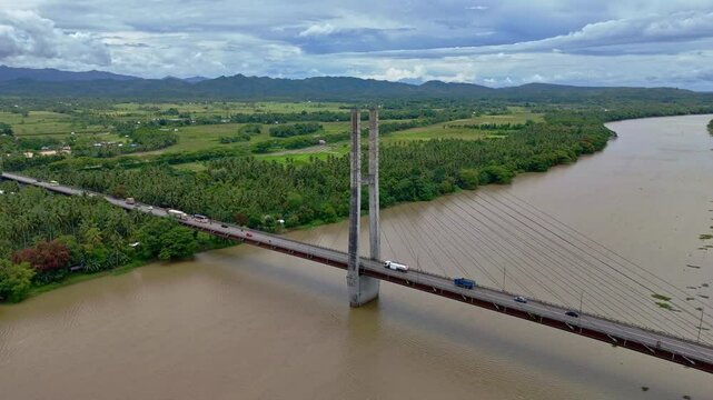 A high aerial shot pans right to left above the Macapagal Bridge bypass spanning the Agusan River in Butuan, Mindanao, Philippines, highlighting this key transportation link.